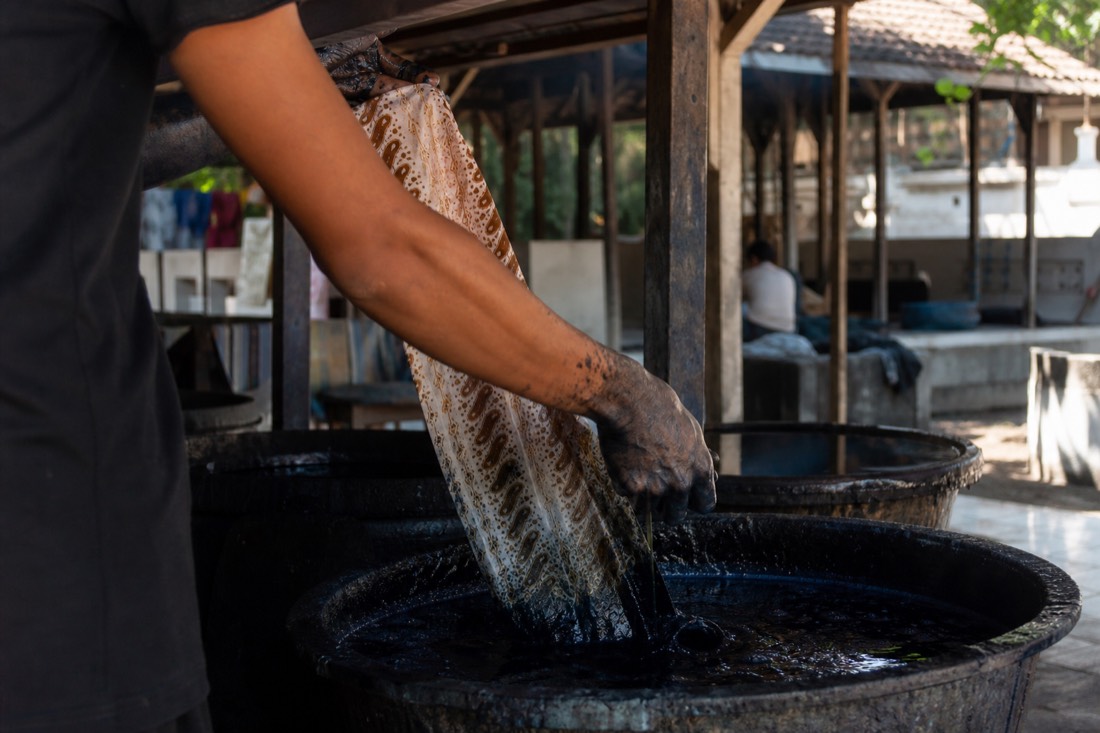 Batik being dyed by hand in a Yogyakarta workshop