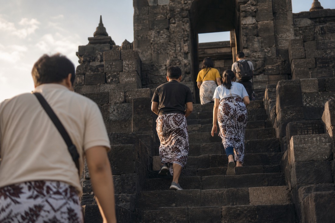 Climbing the steep stone stairway of Borobudur temple