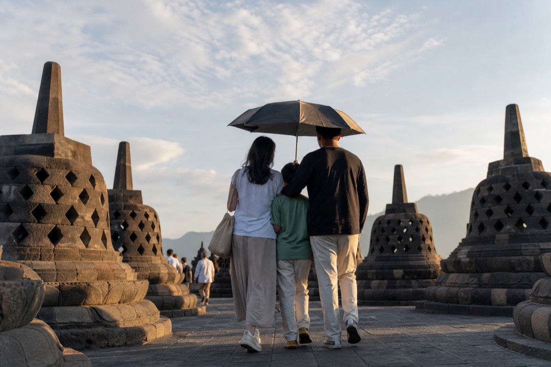 A family crossing the sunlit terrace of Borobudur
