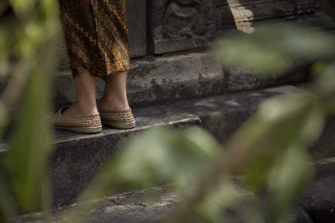 Woven sandals on the worn stone of Borobudur
