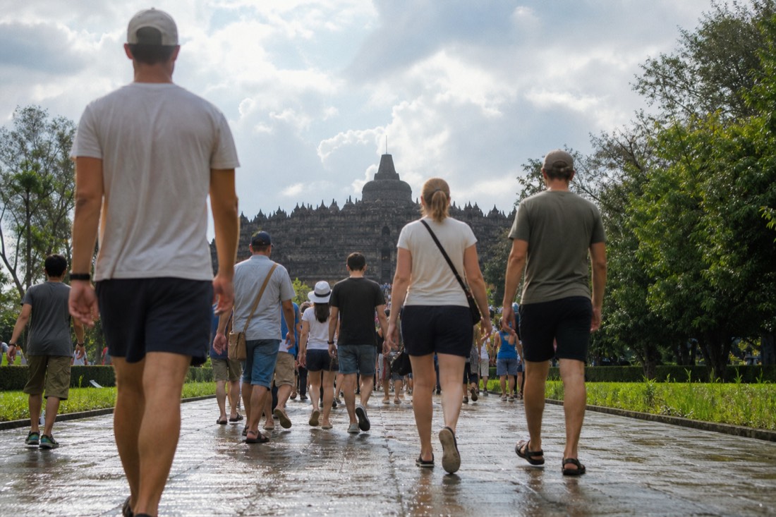 Visitors dressed for the heat walking toward Borobudur