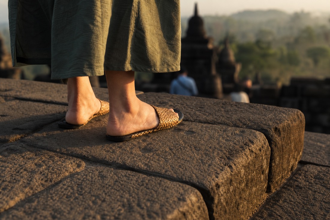 Woven sandals on the worn stone of Borobudur