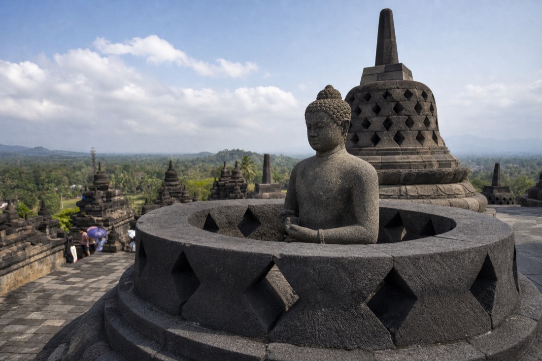 Stone Buddha statue in an opened stupa on Borobudur temple