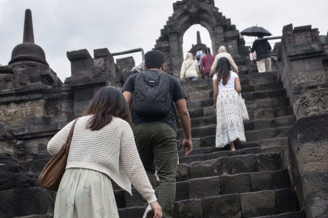 Climbing the steep stone stairway of Borobudur temple
