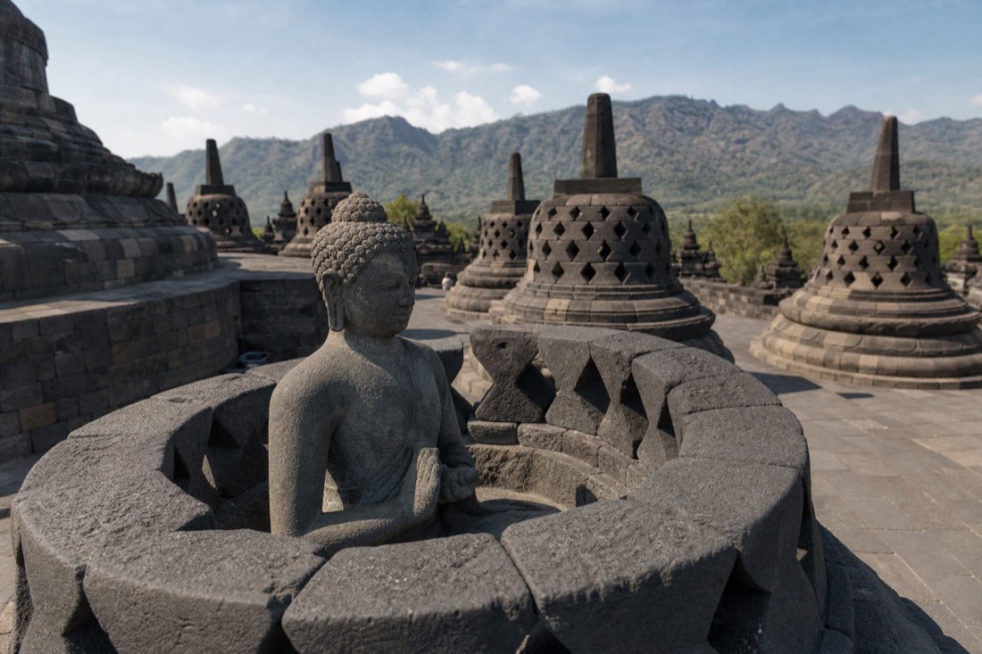 Stone Buddha statue in an opened stupa on Borobudur temple