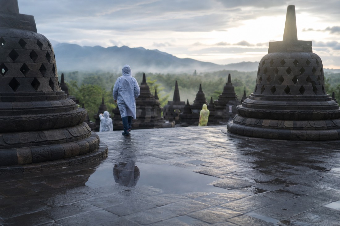 Steaming stone and puddle reflections after rain at Borobudur