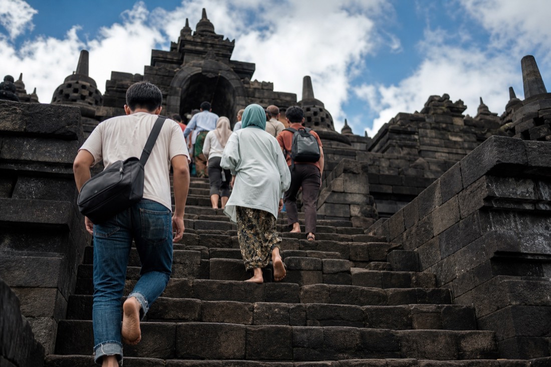Climbing the steep stone stairway of Borobudur temple