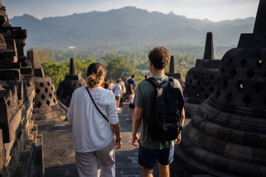 Two visitors dressed differently climbing Borobudur