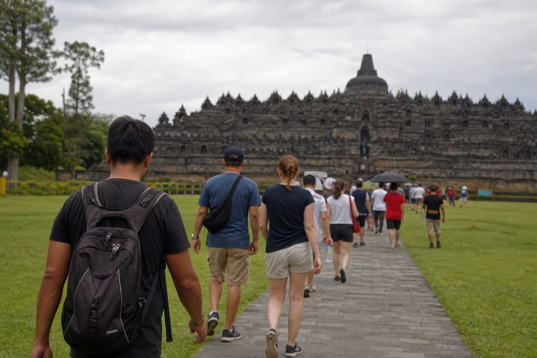 Visitors dressed for the heat walking toward Borobudur