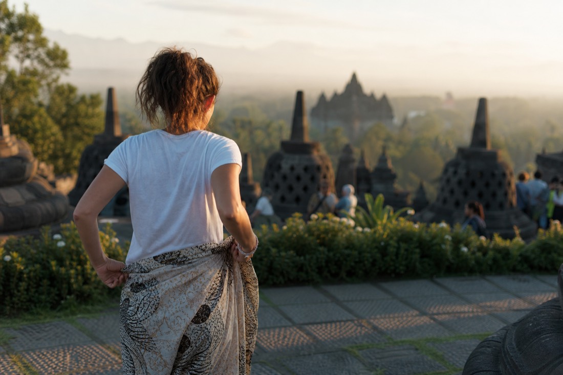 A visitor adjusting a sarong at Borobudur